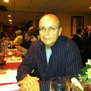 A man sitting at the table with glasses of wine.