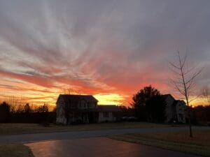 A sunset over houses in the distance.