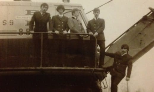A group of men standing on top of a boat.
