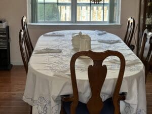 A dining room table with four chairs and a candle.