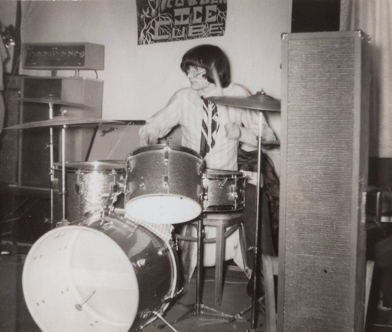 A young boy playing drums in his room.