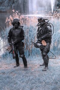 Two soldiers in black suits and helmets standing next to each other.